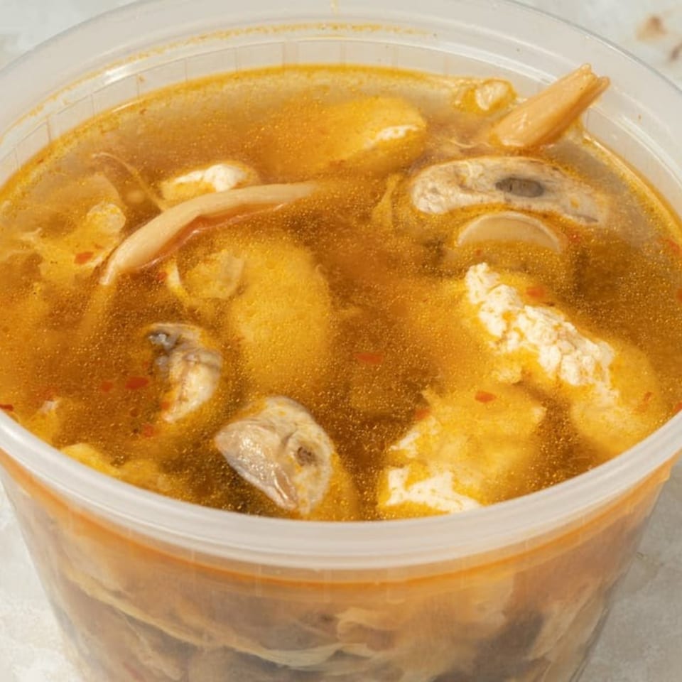 Hot and sour soup from Foo Luck, with mushrooms and tofu, in a clear plastic container.